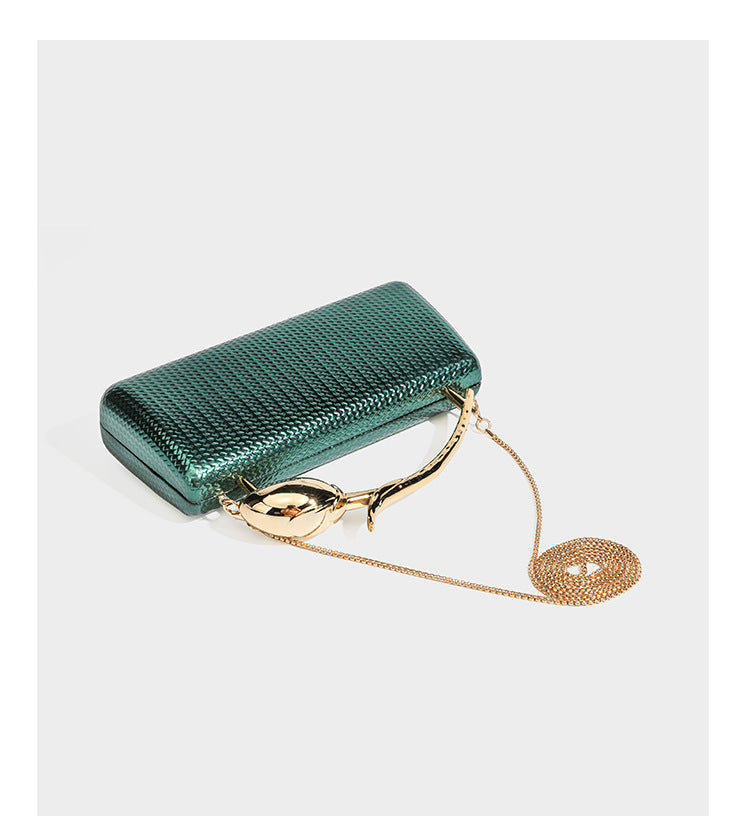 Structured rectangular metallic woven clutch bag with sculptural gold-tone leaf top handle and detachable chain strap, detail