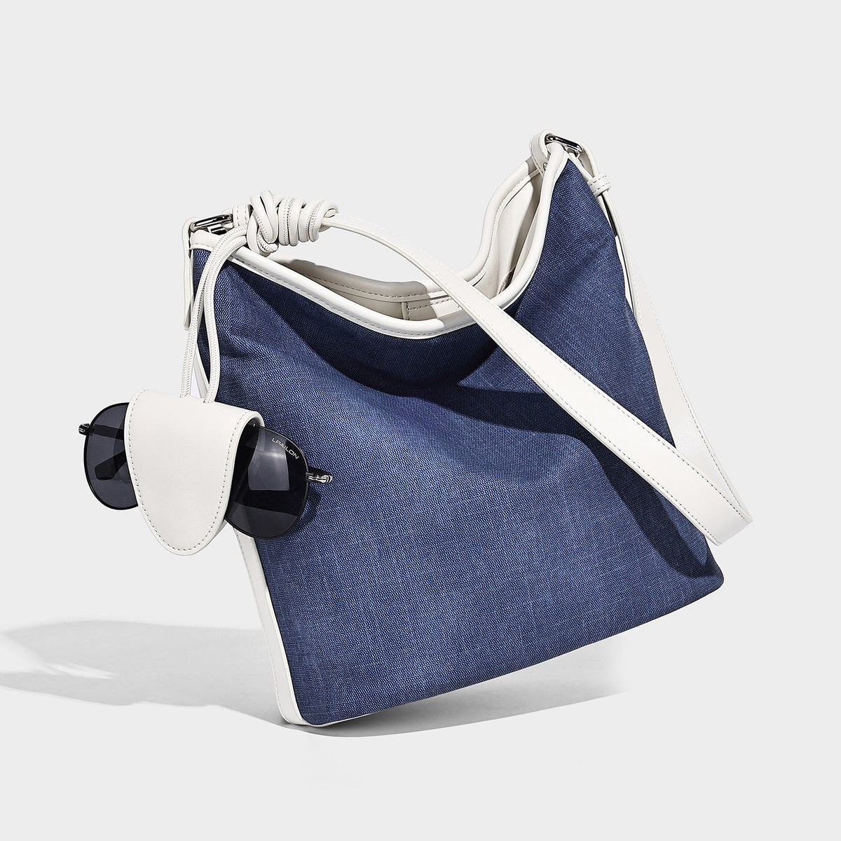 Große Beuteltasche aus Canvas in Denim-Optik mit Besatz in weißer Lederoptik, geknotetem Trageriemen und abnehmbarem Mini-Täschchen auf der Vorderseite