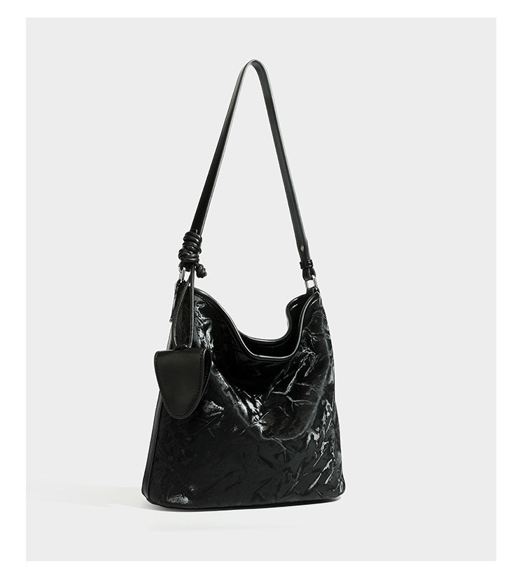 Große Hobo-Schultertasche mit Crinkle-Glanzfinish in Dunkelbraun, schmalem verstellbarem Riemen, geknoteten Beschlägen und seitlich befestigter Klappe