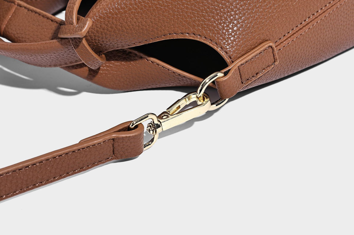 Structured pebbled-texture bucket bag with arched top handles, gold-tone turn-lock closure, and detachable shoulder strap