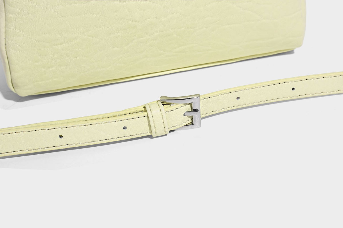 Mini-Tasche mit strukturierter Kuppelform und Tragegriff, in Pastellgelb mit genarbter Lederoptik, silberfarbenen Metallbeschlägen und abnehmbarem