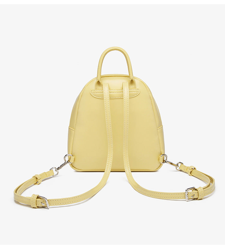 Kleine kuppelförmige Mini-Rucksackhandtasche in Pastellgelb mit glatter Lederoptik, oberem Bogenreißverschluss und silberfarbenen Details, Detailansicht