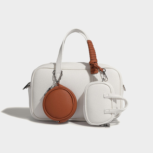Structured pebbled leather-look Boston bowling bag in tan with blue detachable round mini pouch, dual top handles, and