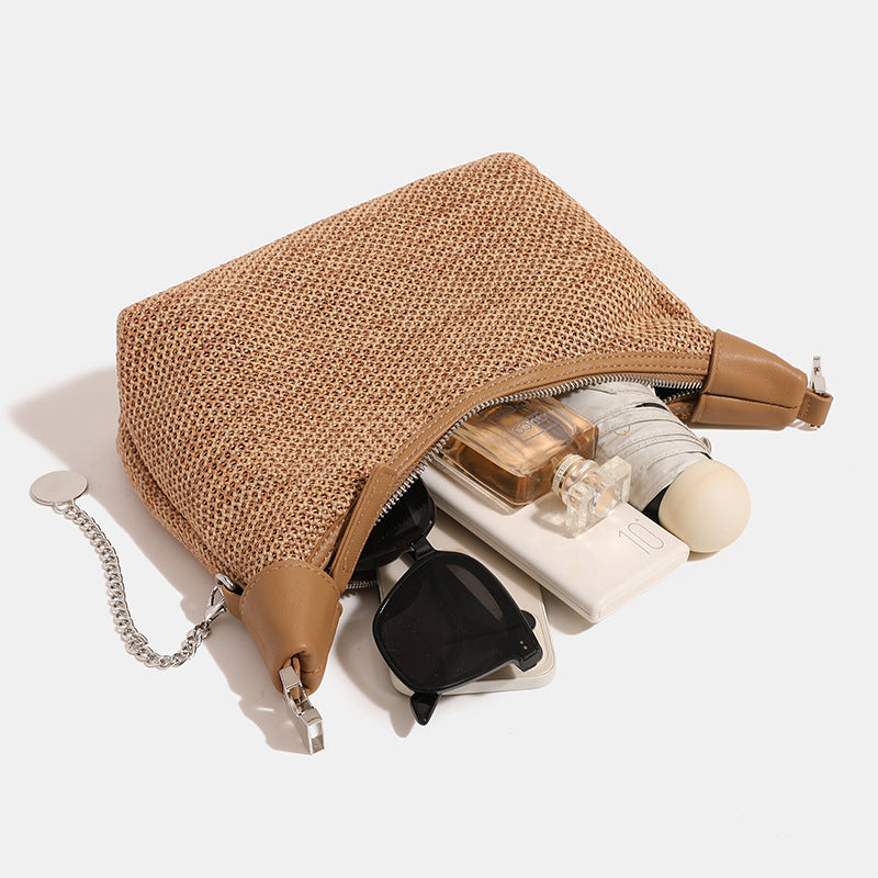 Geflochtene Hobo-Bag aus Stroh mit geknotetem Tragegriff in Lederoptik, silberfarbenen Details und Kettenanhänger in Schwarz und Camel