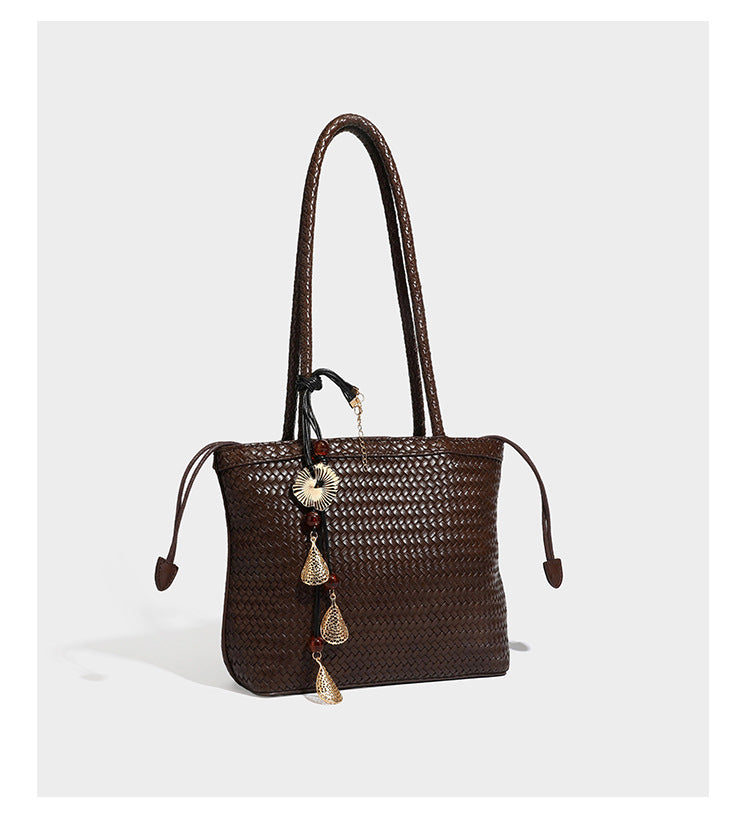 Structured woven leather-look tote bag in dark brown with long shoulder straps, side drawstring ties, and gold filigree