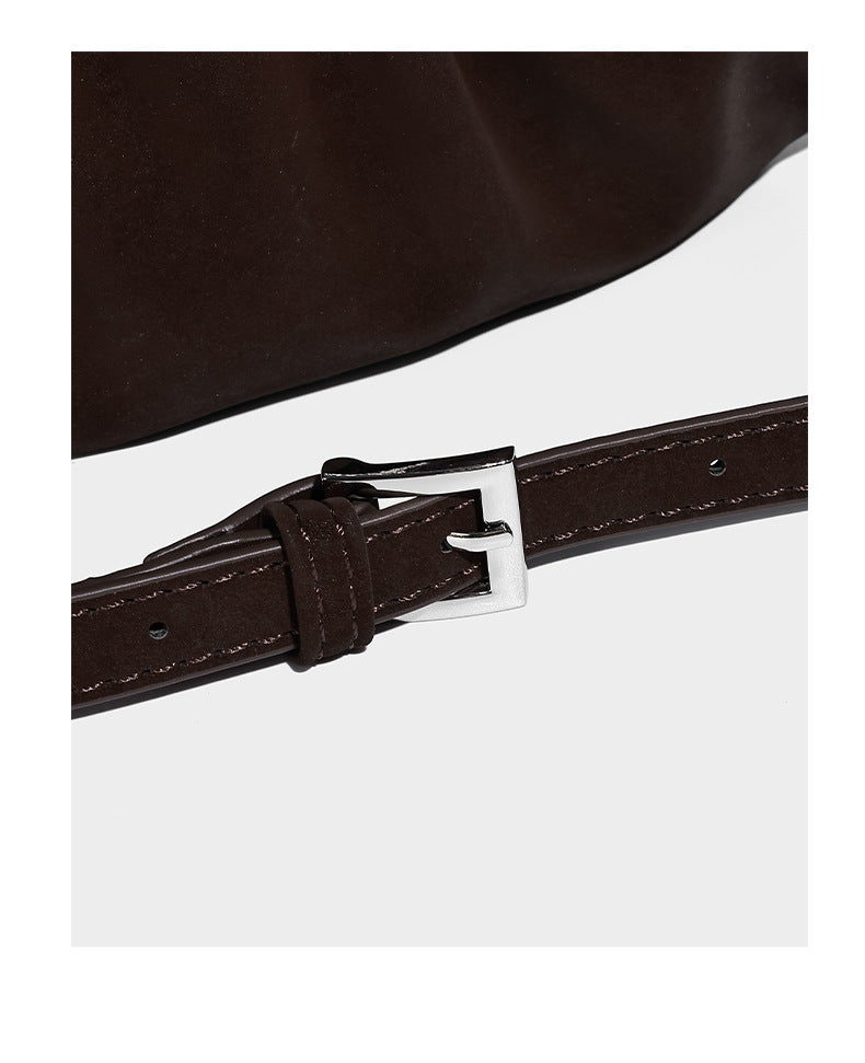 Ruched shoulder bag with curved flap, silver star studs, dangling starfish charm, and adjustable crossbody strap, detail view