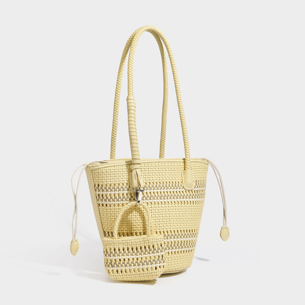 Light blue open-weave woven bucket tote bag with long braided shoulder straps, drawstring side ties, and attached mini pouch