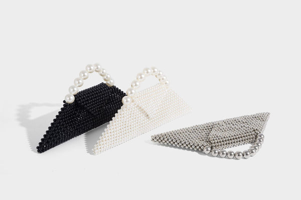 Small structured triangle clutch bag covered in glossy pearl beads with an arched pearl top handle and silver snap closure