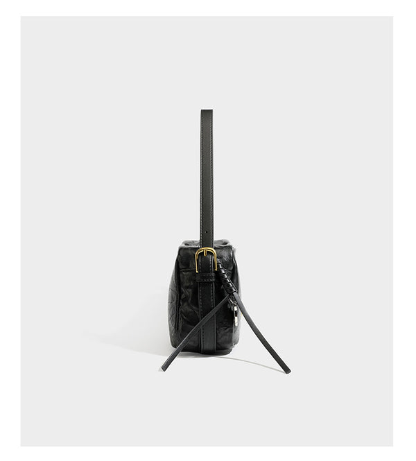 Compact black crinkled leather-look baguette shoulder bag with gold-tone arch hardware and adjustable strap, detail view 9