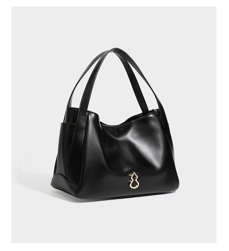 Structured glossy leather-look tote shoulder bag with dual top handles, detachable crossbody strap, side pockets, and, detail