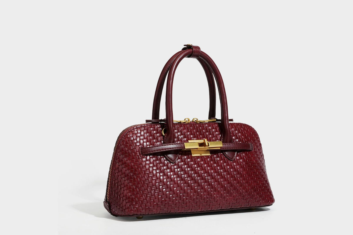 Structured woven-embossed leather-look satchel with dual rolled top handles, gold-tone turn-lock closure, and detachable