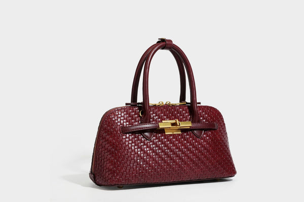 Structured woven-embossed leather-look satchel with dual rolled top handles, gold-tone turn-lock closure, and detachable