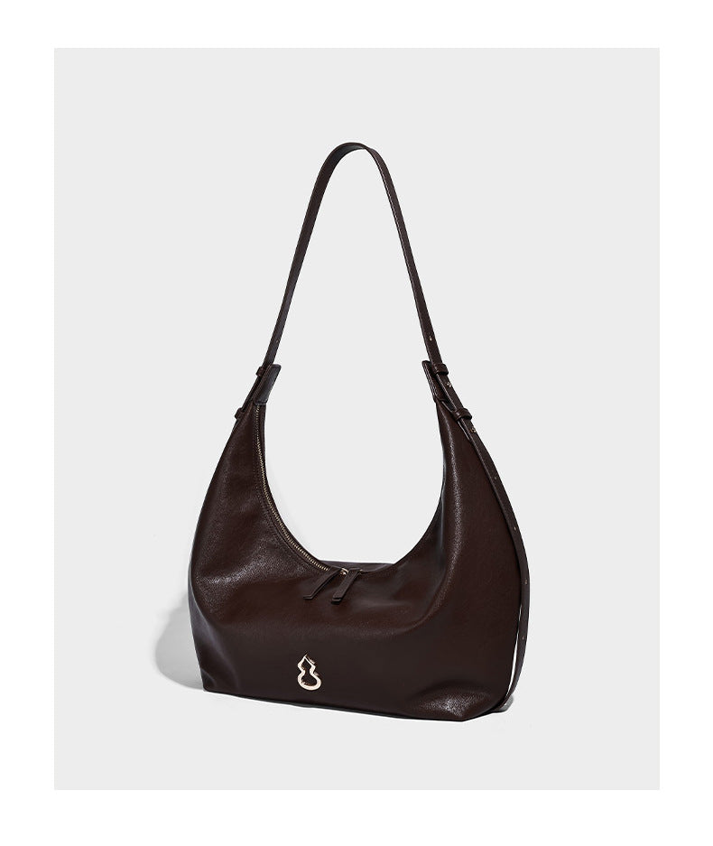 Lässig fallende, sichelförmige Hobo-Schultertasche in glatter dunkelbrauner Lederoptik mit Logo-Anhänger in Goldoptik und verstellbarem Schulterriemen