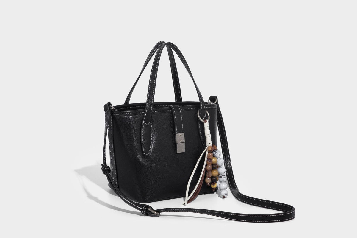 Compact structured bucket tote bag with pebbled textured finish, dual top handles, silver-tone lock hardware, and detachable