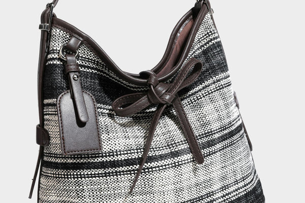 Schwarz-weiß karierte Hobo-Schultertasche aus gewebtem Material mit dunkelbrauner Einfassung in Lederoptik, Kordelzugverschluss und langem, verstellbarem