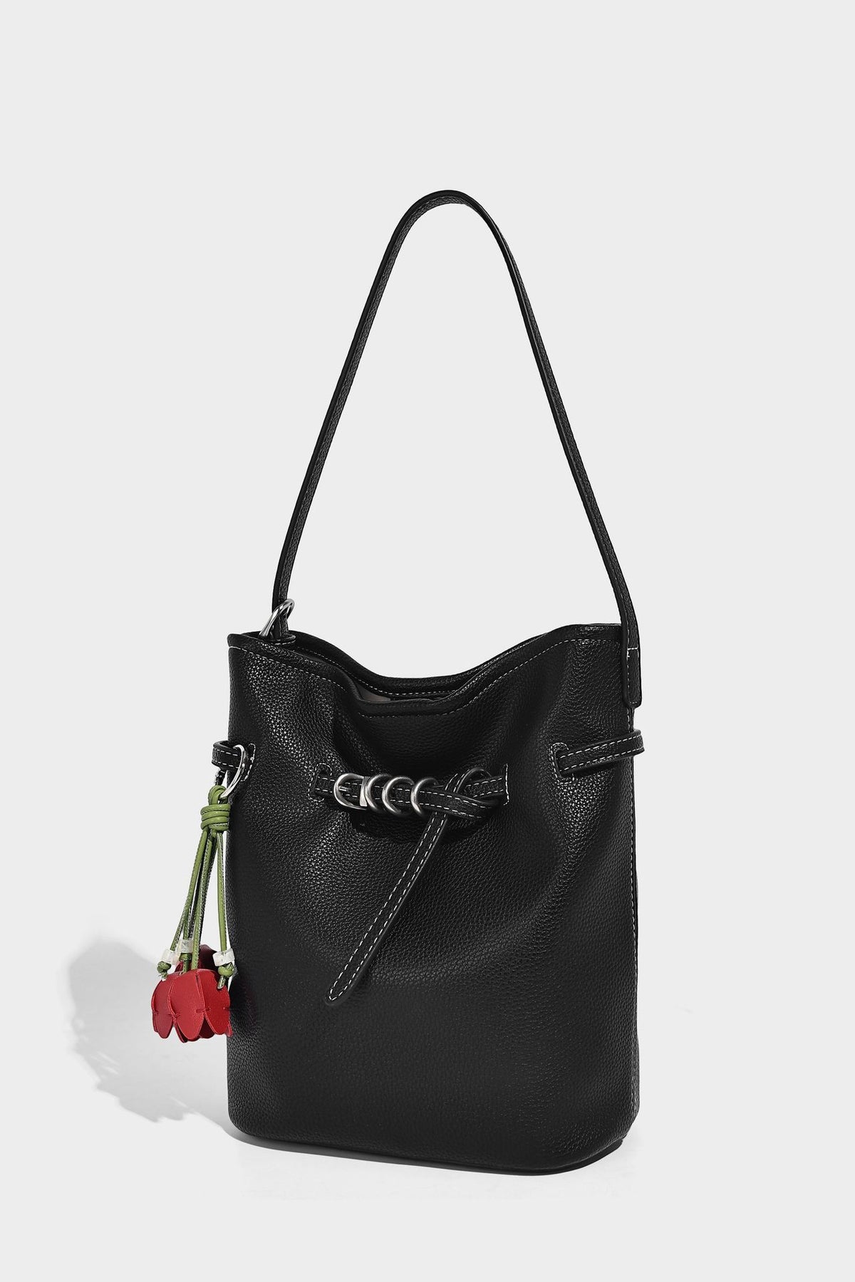 Small pebbled leather-look bucket bag with front drawstring toggle hardware and long adjustable shoulder strap, detail view