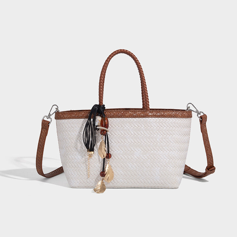 Structured chevron woven leather-look tote bag with braided top handles, gold feather charm, and adjustable shoulder strap