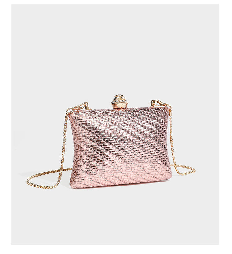 Small structured rectangular metallic woven-texture clutch bag with jeweled knob clasp and gold-tone chain strap, detail view