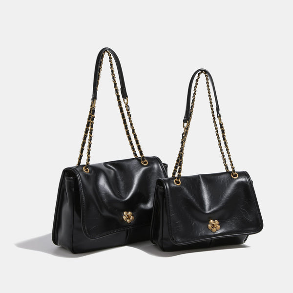 Structured flap shoulder bag with antique gold-tone chain strap and flower turn-lock clasp in crinkled leather-look finish