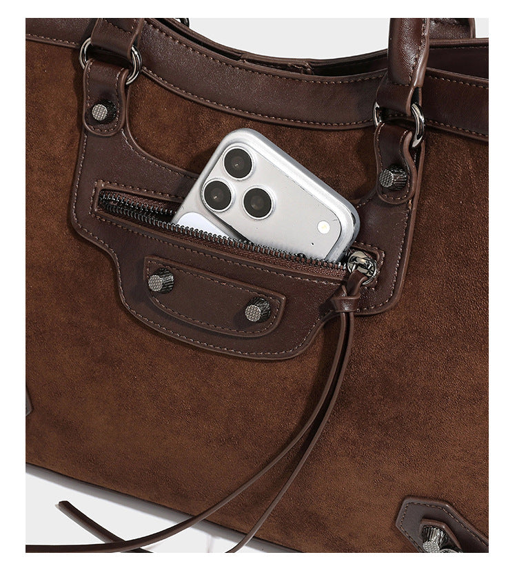 Large structured tote bag with matte suede-like body, smooth leather-look trim, front zip pocket, stud hardware, and