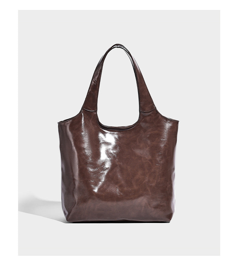 Glossy oil-wax leather-look open-top tote shoulder bag with embossed circular logo and long double straps, detail view 11