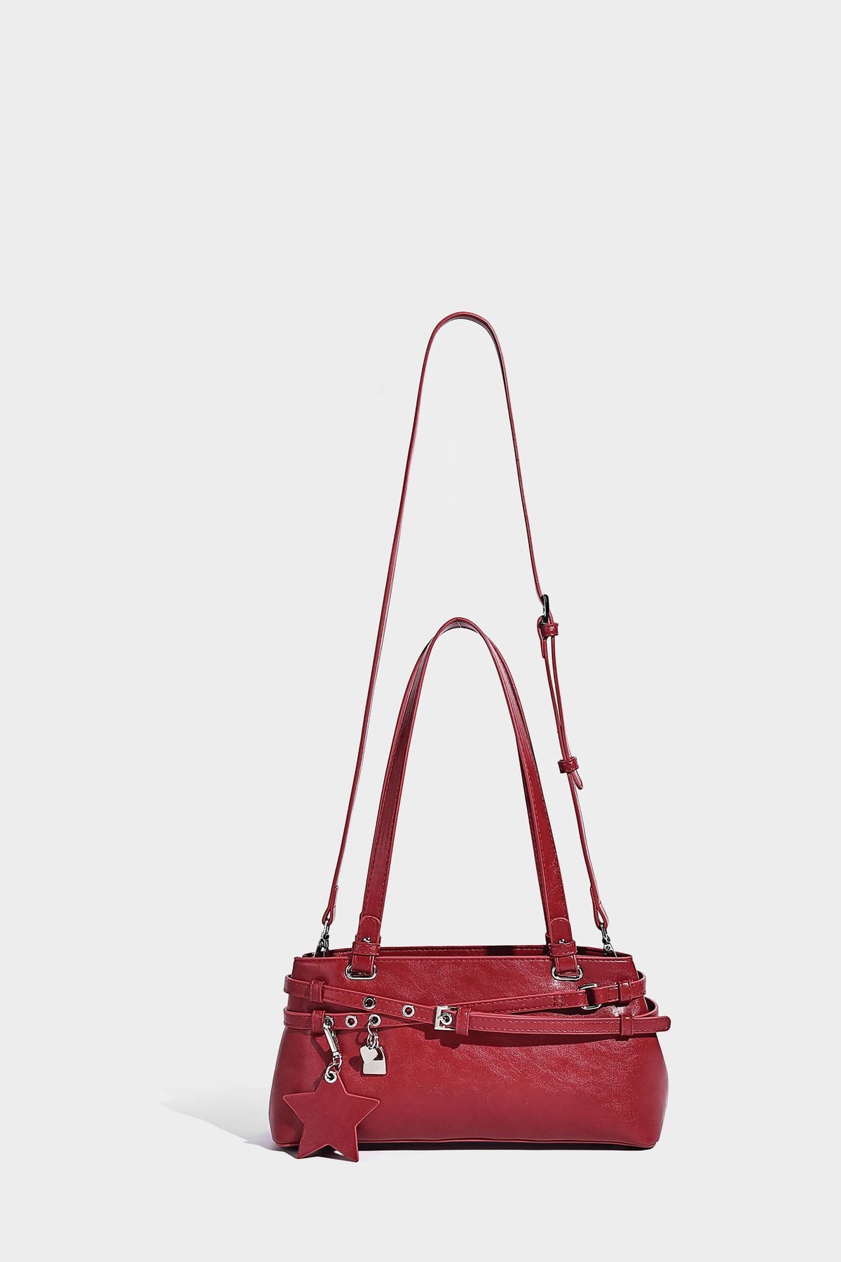 Structured glossy leather-look shoulder bag with wraparound belt straps, silver-tone hardware, and dangling star charm