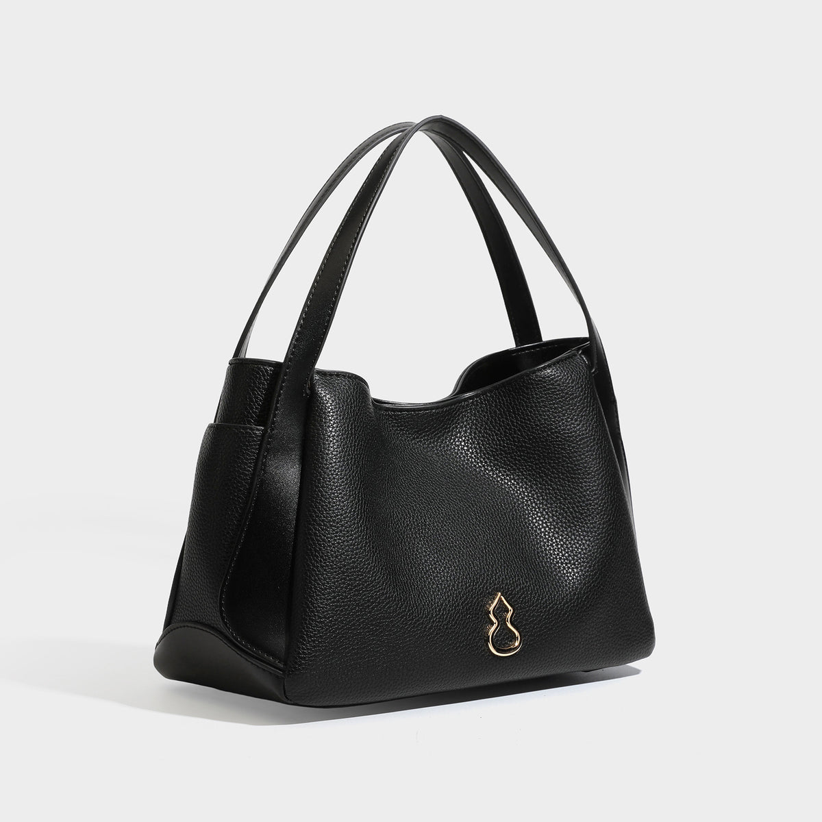 Schwarze Tote-Bag in genarbter Lederoptik mit kürbisförmigen Beschlägen in Goldoptik, zwei Tragegriffen und abnehmbarem Crossbody-Schulterriemen, Detailansicht