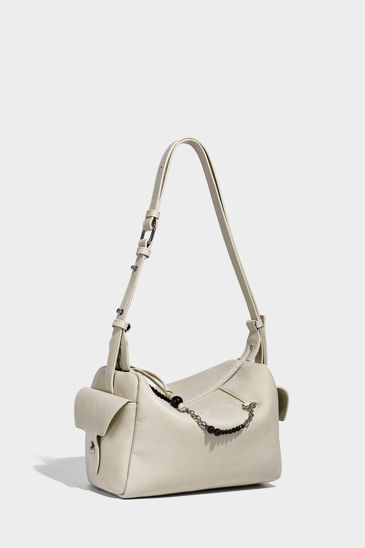 Small slouchy moto-style crossbody bag in smooth matte leather-look finish with white contrast stitching, silver-tone, detail