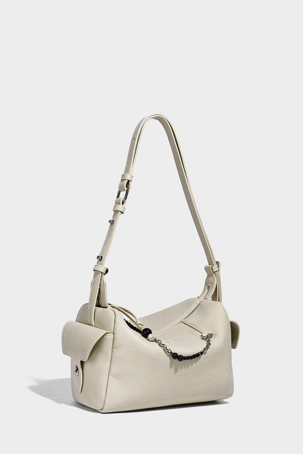 Small slouchy moto-style crossbody bag in smooth matte leather-look finish with white contrast stitching, silver-tone, detail
