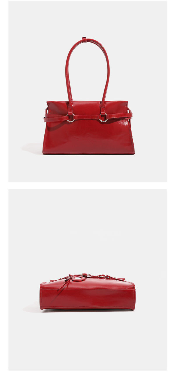 Strukturierte, glänzende trapezförmige Schultertasche mit zwei Tragegriffen, umlaufendem Riemen, silberfarbener Schnalle und hängendem