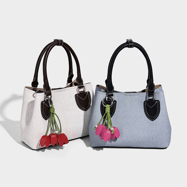 Structured light-blue denim-look tote bag with black leather-look handles, white contrast stitching, silver-tone hardware