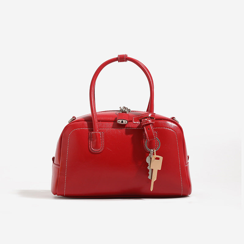 Compact retro Boston satchel bag with matte suede-look finish, twin rounded top handles, double zip closure with silver-tone