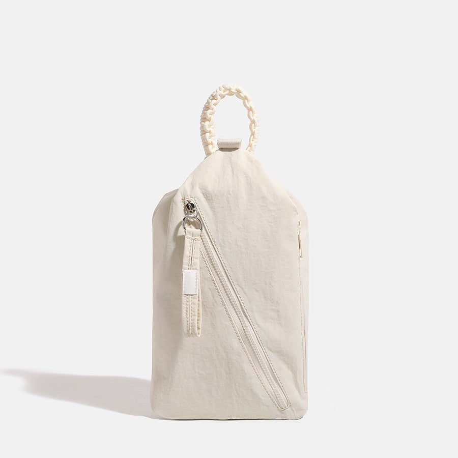 Slouchy soft-fabric crossbody bag with braided rope top handle, diagonal front zip pocket, and silver-tone hardware, detail