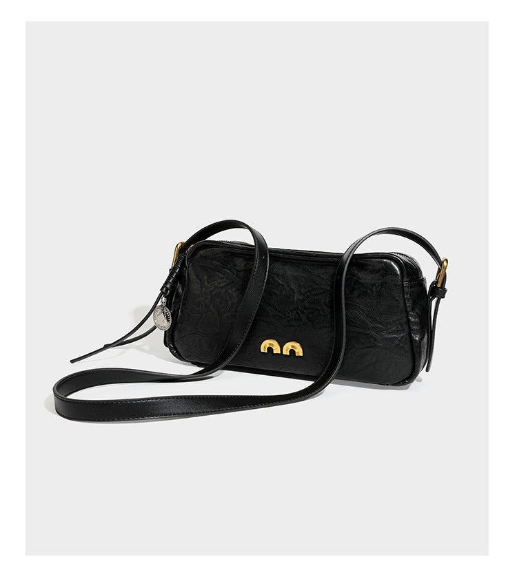 Compact black crinkled leather-look baguette shoulder bag with gold-tone arch hardware and adjustable strap, detail view 11