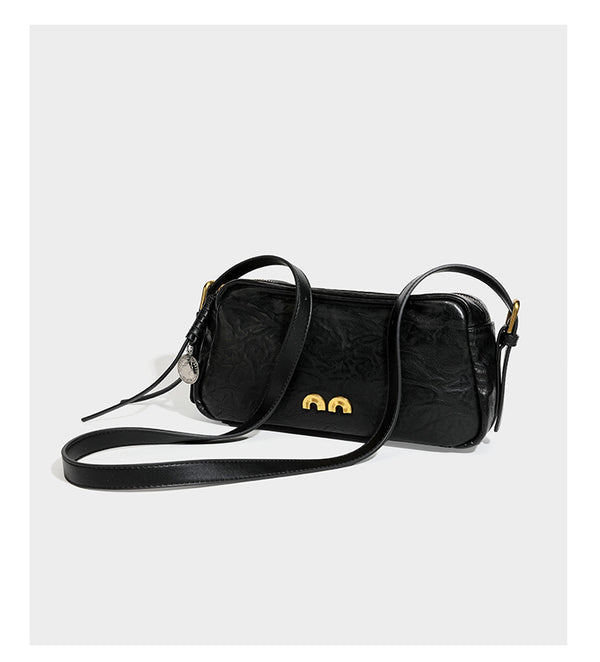 Compact black crinkled leather-look baguette shoulder bag with gold-tone arch hardware and adjustable strap, detail view 11