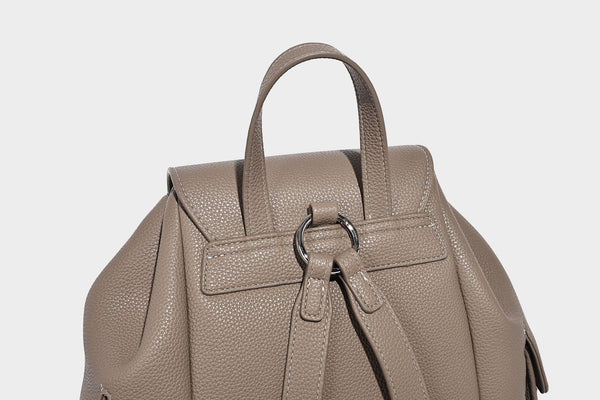 Compact pebbled leather-look flap drawstring backpack handbag with side pockets, top handle, and silver-tone hardware, detail