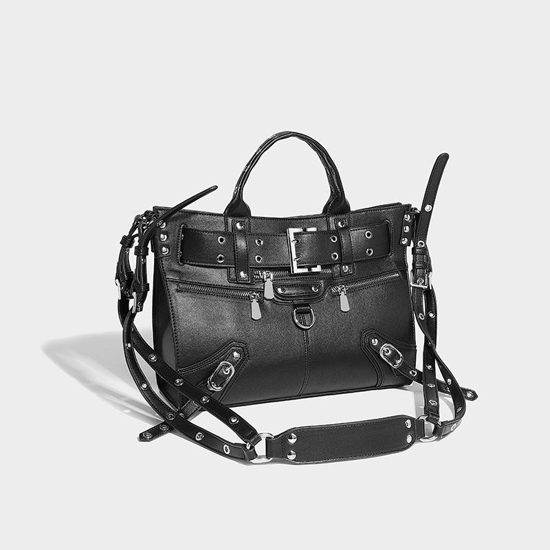 Black structured rectangular satchel bag with silver-tone rivets, large front buckle strap, zip pockets, dual top handles