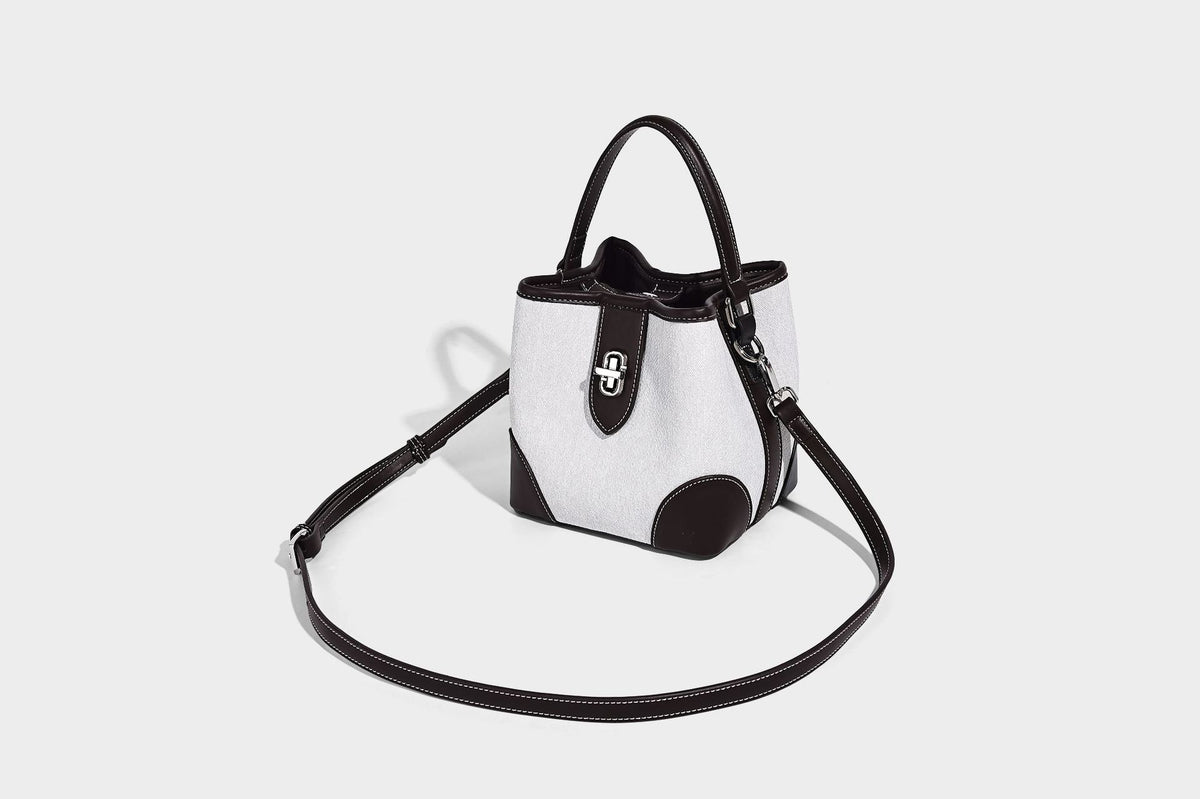 Small structured bucket bag in denim-look light blue fabric with black leather-look trim, silver turn-lock hardware, short