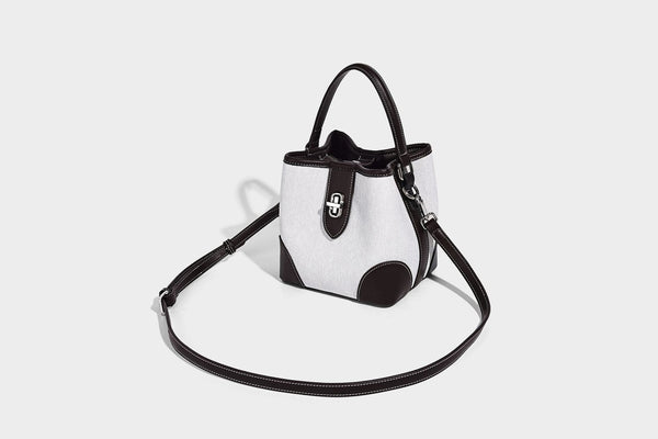Small structured bucket bag in denim-look light blue fabric with black leather-look trim, silver turn-lock hardware, short