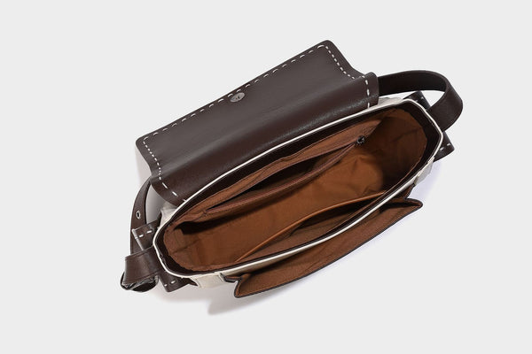 Structured flap crossbody bag in dark brown and cream color-block with white contrast stitching, adjustable shoulder strap