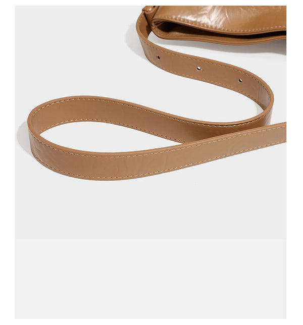 Lässige Hobo-Schultertasche mit offenem oberen Abschluss in glänzender karamellfarbener Lederoptik mit goldfarbenen Logo-Beschlägen und langem, verstellbarem