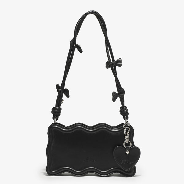Small structured scalloped-edge shoulder bag with bow-tied pink cord strap and silver heart charm pendant, detail view 8