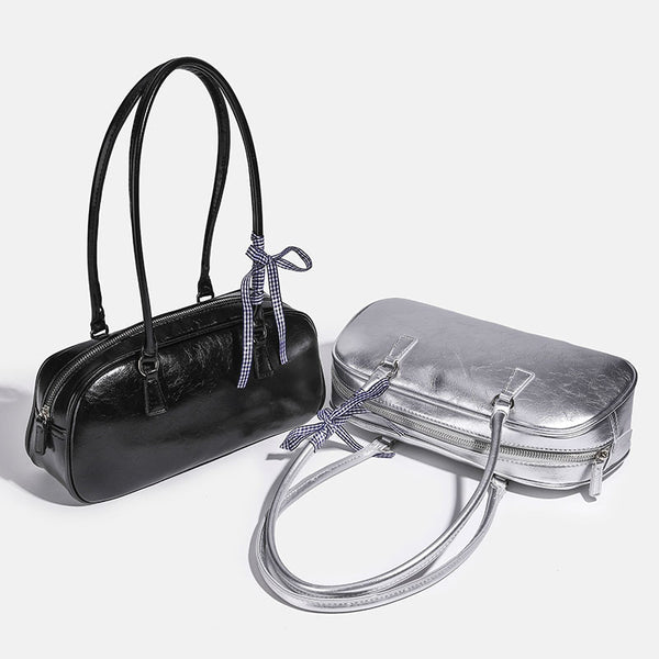 Rounded rectangular shoulder bag with glossy crinkled finish, dual long handles, top zip closure, and gingham ribbon bow