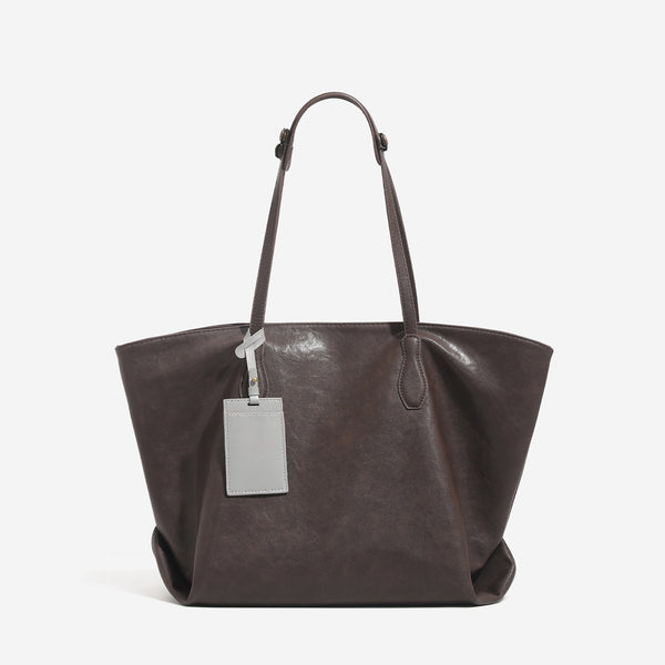 Large leather-look tote bag with trapezoid silhouette, double shoulder straps, and detachable hanging tag, detail view 7