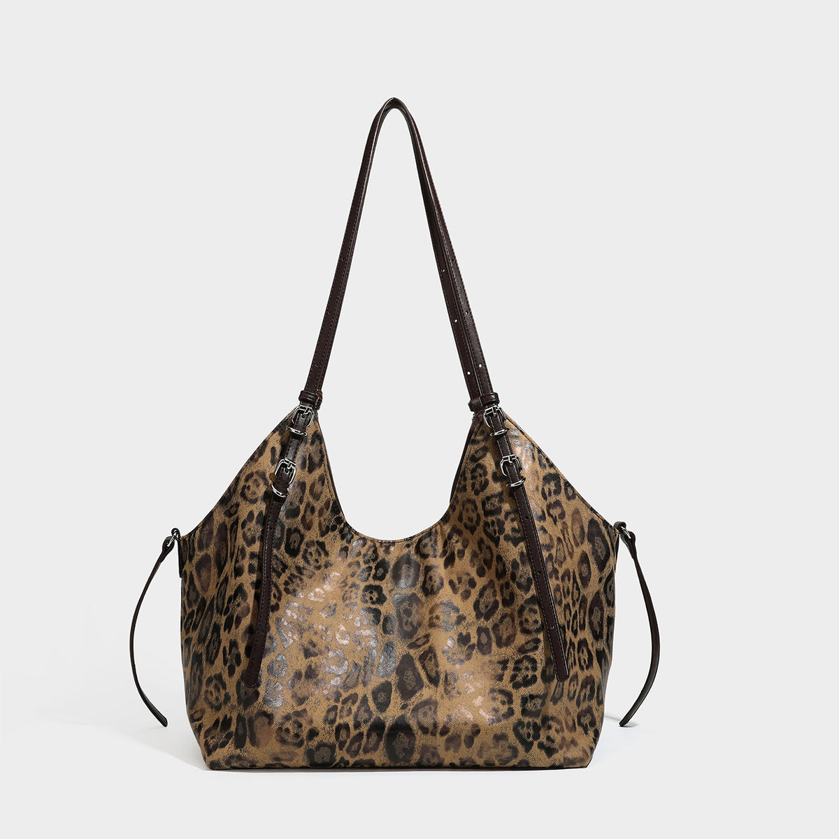 Slouchy leopard-print shoulder tote bag in tan and brown with long double straps, side tie straps, and dangling charm, detail