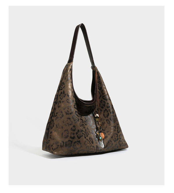 Weich fallende Hobo-Tote-Bag mit Leopardenmuster in Beige und Braun, dunkelbraunem Riemen in Lederoptik und herabhängenden Perlenanhänger-Beschlägen