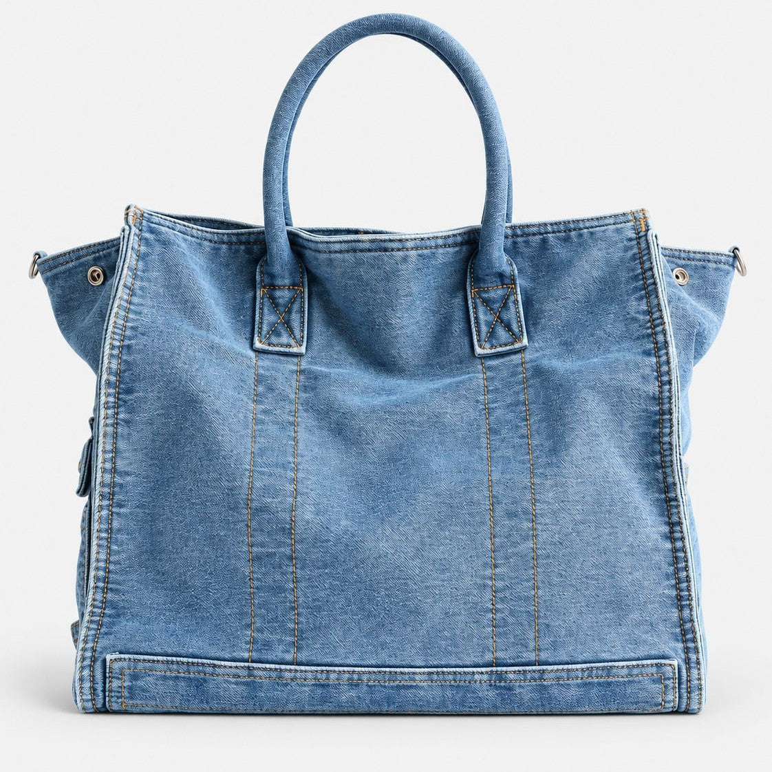 Large washed denim patchwork tote bag with snap-flap front pockets, rolled handles, and detachable shoulder strap, detail
