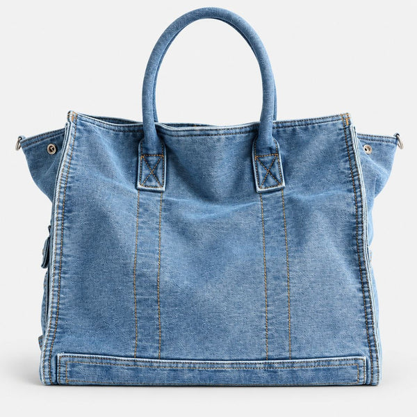 Large washed denim patchwork tote bag with snap-flap front pockets, rolled handles, and detachable shoulder strap, detail