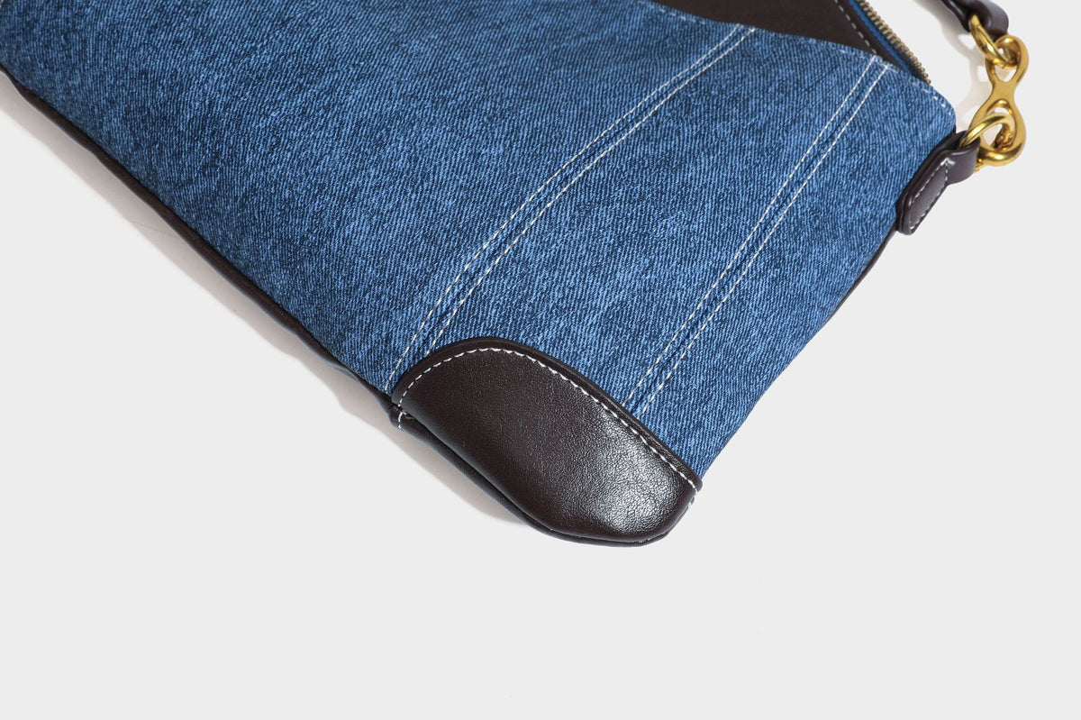 Slouchy denim shoulder bag with dark leather-look trim, gold-tone chain-link hardware, and top zipper closure, detail view 36