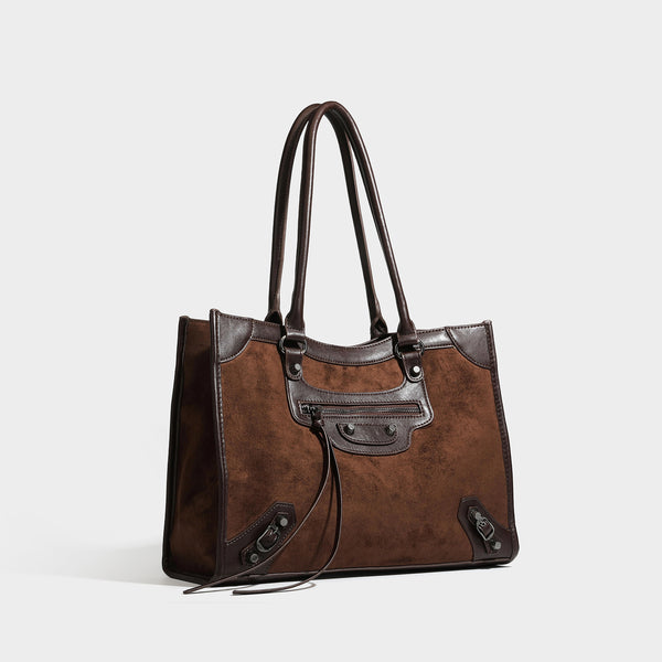 Large structured tote bag with matte suede-like body, smooth leather-look trim, front zip pocket, stud hardware, and